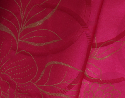 Détail d'une broderie florale rose sur un Bazin Getzner authentique, montrant la finesse du travail de confection.