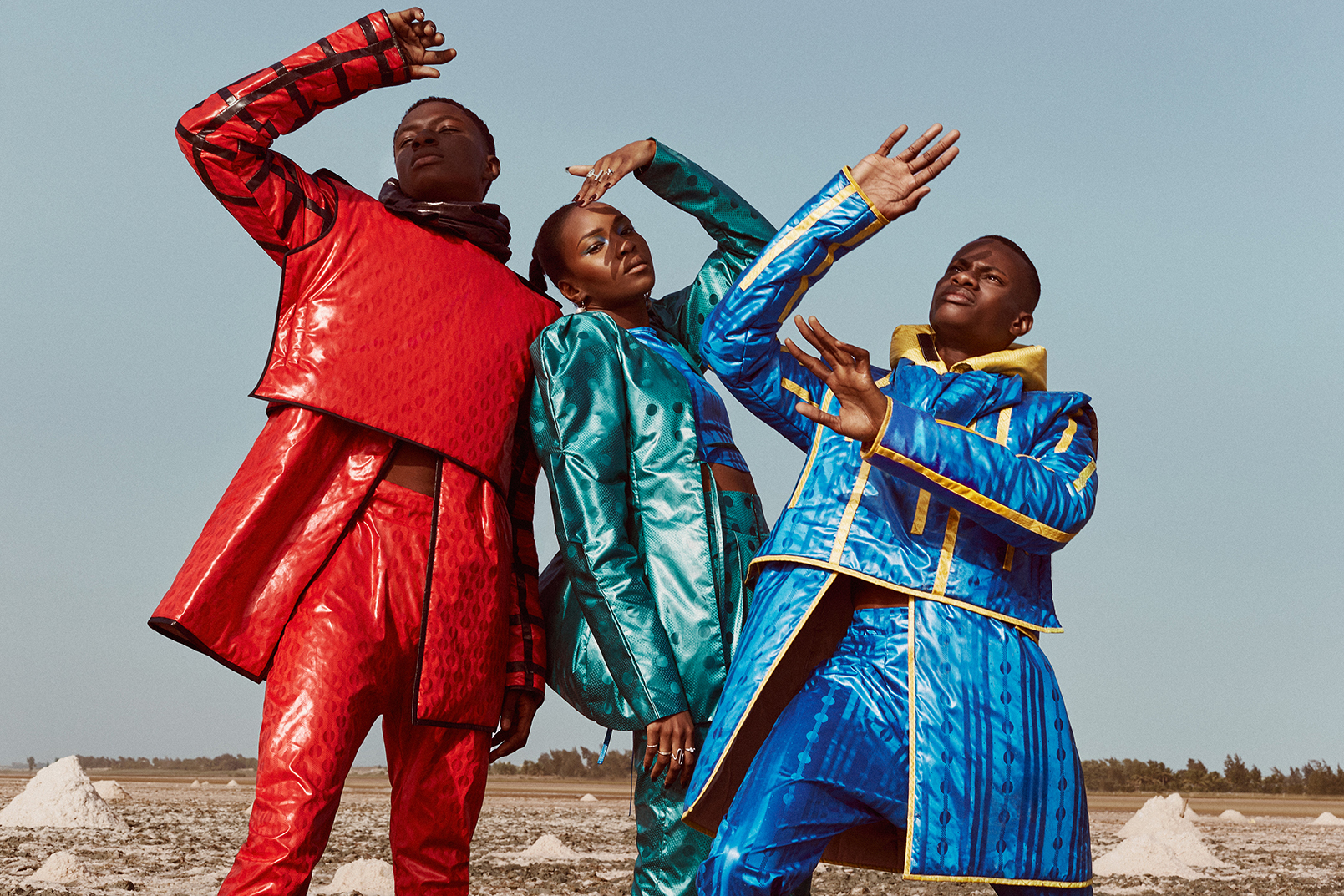 Groupe de 3 personnes habillés en bazin rouge, bazin vert et bazin bleu