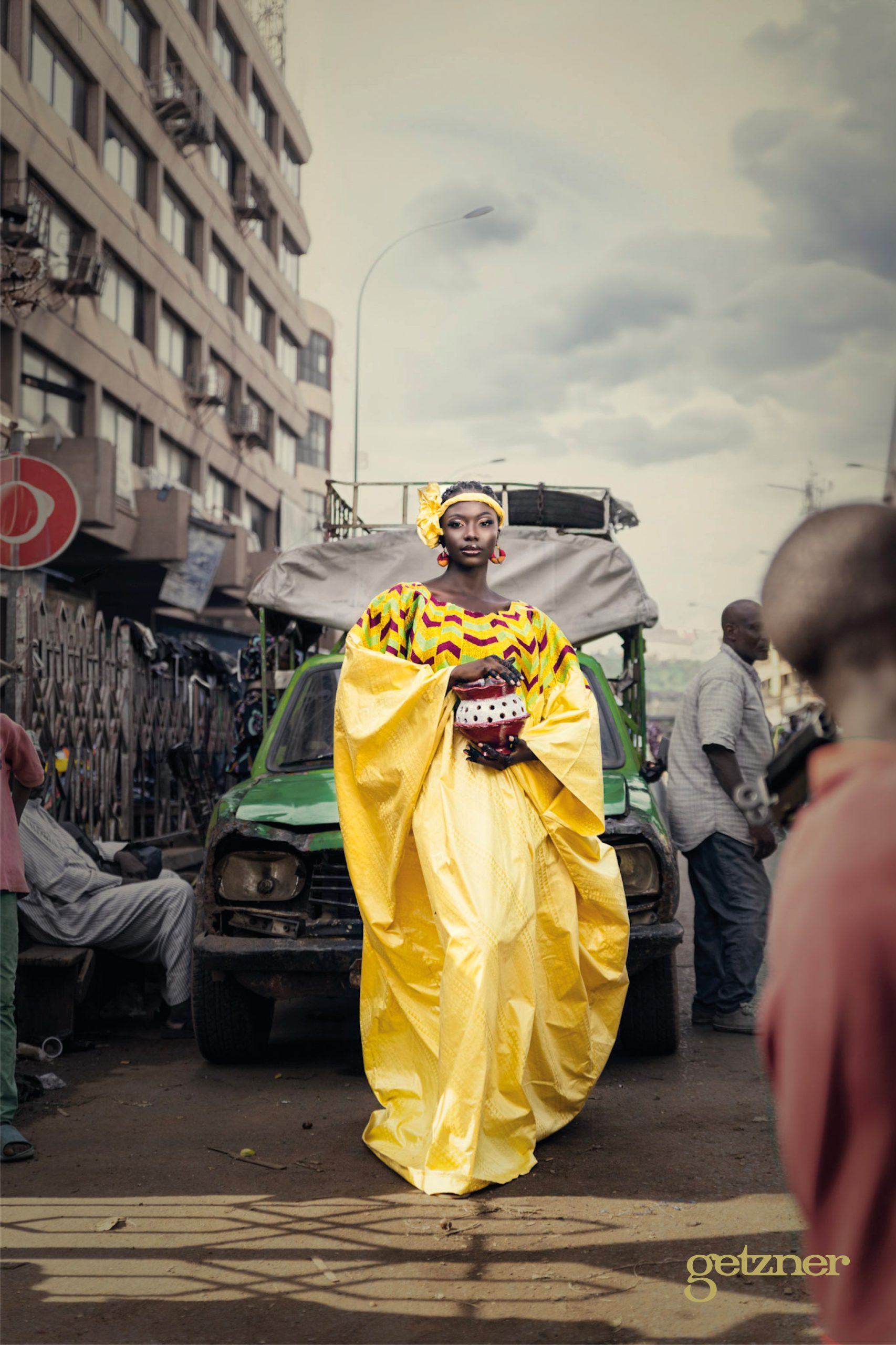 Photographie d'une femme en robe Getzner faite de bazin, de couleur jaune ou dorée