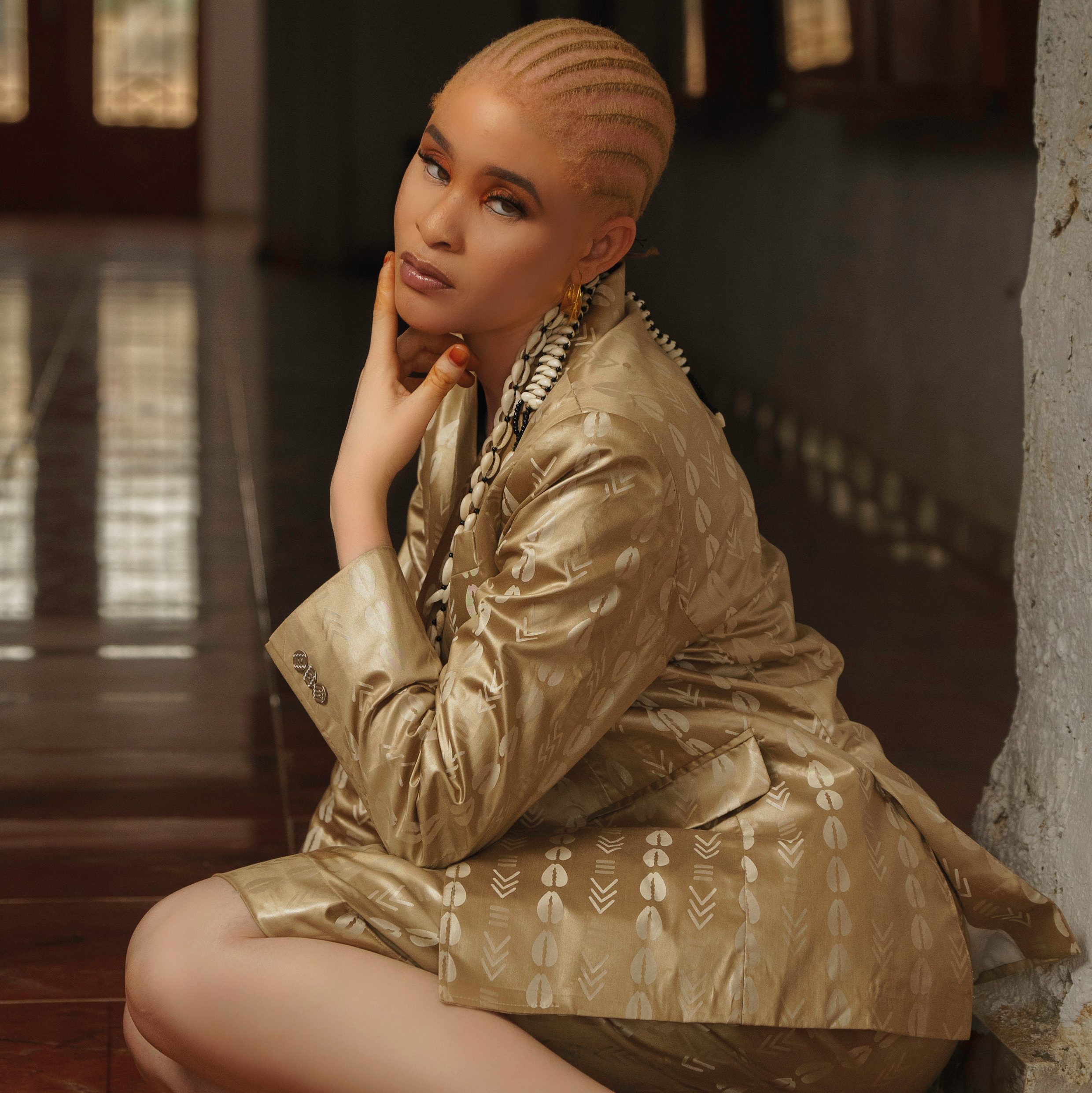 Femme avec des tresses et un ensemble fait de bazin doré